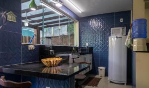 a kitchen with blue tiled walls and a sink at Chalé Sossego in Lençóis