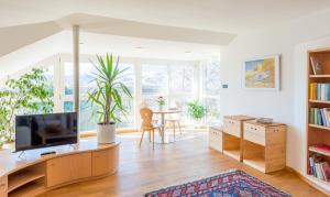 een woonkamer met een televisie en een tafel bij Villa Sonnenschein in Terlano