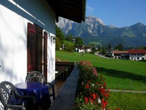 a porch of a house with a table and flowers at Ferienwohnungen Fendt in Bischofswiesen