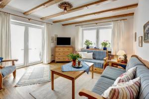 a living room with two couches and a tv at Ferienwohnungen Fendt in Bischofswiesen