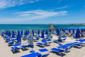 a bunch of chairs and umbrellas on a beach at La Casetta sul Mare in Isola delle Femmine