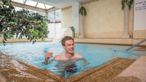 a man in a pool in a swimming pool at Strass - Sport & Spa Hotel in Mayrhofen