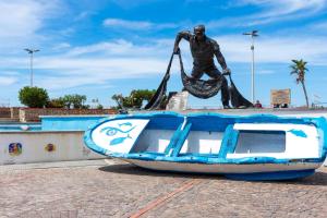 a statue of a man standing on a boat at La Casetta sul Mare in Isola delle Femmine