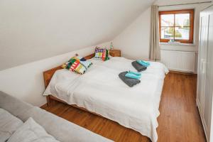 um quarto com uma cama branca com almofadas e uma janela em Rhönpanorama em Hilders