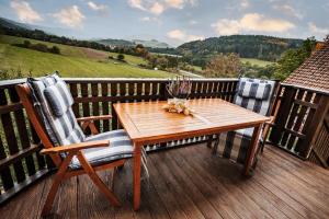 einen Holztisch und zwei Stühle auf einer Terrasse in der Unterkunft Rhönpanorama in Hilders