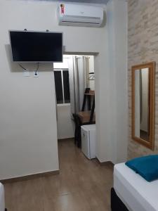 um quarto com uma televisão numa parede branca em Hotel Serra do Mar em Paranaguá