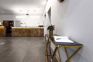 a room with a table, a chair, and a wall at In Gold Hotel & Spa in Águeda