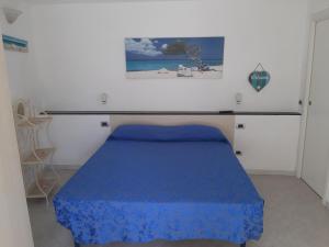 een slaapkamer met een bed met een blauwe sprei bij Appartamento Il giardino in Levanto