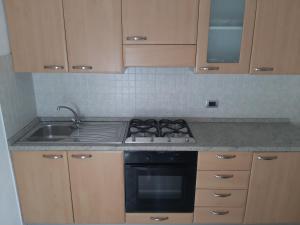 een keuken met een fornuis en een spoelbak bij Appartamento Il giardino in Levanto
