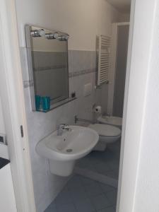 een witte badkamer met 2 wastafels en een spiegel bij Appartamento Il giardino in Levanto