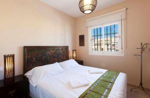 1 dormitorio con 1 cama blanca grande y ventana en Tarifa Beach Rentals Tortuga 2, en Tarifa
