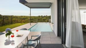 a dining room with a table and a swimming pool at Villa Noble 2 by Villas Holiday in Bale