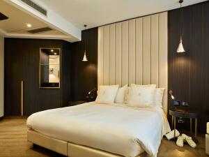 um quarto com uma cama grande e almofadas brancas em Hotel Niccolo' V - Terme dei Papi em Viterbo
