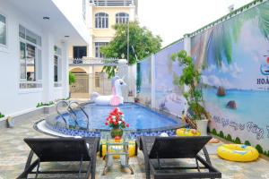 een patio met een zwembad met een muurschildering van een eenhoorn bij Shiny Villa Vung Tau in Vung Tau