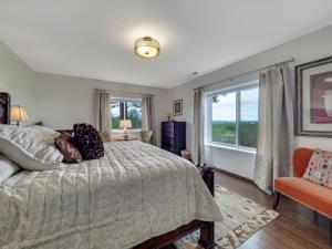 um quarto com uma cama e uma grande janela em Harbor View Getaway em Petoskey