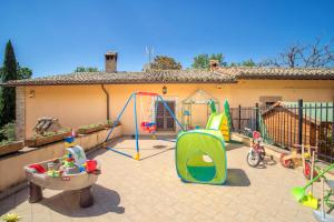 um quintal com um conjunto de jogos e um parque infantil em L'Agrifoglio di Assisi Residenza di Campagna em Assis