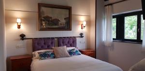 a bedroom with a bed and a picture on the wall at Amaicha Hotel Rural in Ribadesella