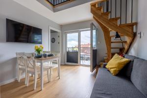 a living room and dining room with a table and chairs at Apartamenty na wydmach in Łeba