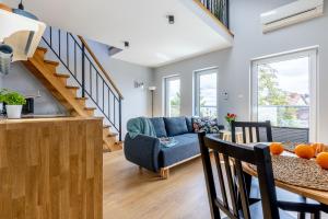 a kitchen and living room with a staircase and a table at Apartamenty na wydmach in Łeba