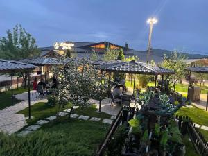 a garden with tables and chairs under umbrellas at Ribarski konaci in Doboj