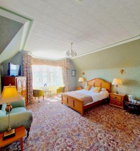 een slaapkamer met een bed, een stoel en een raam bij Corriemar House in Oban