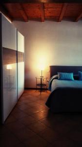 1 dormitorio con 1 cama y 1 mesa con lámpara en Agriturismo Corte Speranza, en Guidizzolo