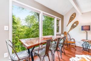 a dining room with a table and chairs and a large window at The Hemlock Hideaway in Sugar Mountain