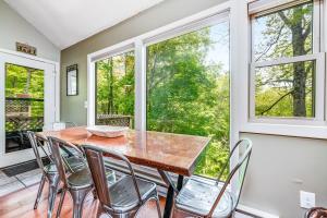 a dining room with a table and chairs and windows at The Hemlock Hideaway in Sugar Mountain +21 photos