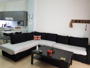 uma sala de estar com um sofá preto e branco e uma mesa em Kelly's home sweet home em Tessalônica