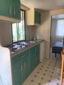 a kitchen with green cabinets and a stove top oven at Maronda Camping in Marina di Montenero +72 photos