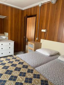 a bedroom with a bed and a dresser and a bed sidx sidx sidx sidx at Maronda Camping in Marina di Montenero