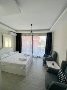 a bedroom with a bed and two chairs and a couch at Cilek Butik Hotel in Çeşme