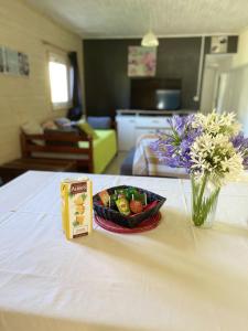 a table with a bowl of food and a vase of flowers at Maison de 2 chambres avec terrasse amenagee et wifi a La Plaine des Cafres in La Plaine des Cafres