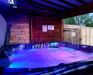 a hot tub in a room with purple water at Welsh Row House in Llandegla