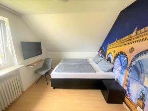 1 dormitorio con 1 cama con una pintura en la pared en Olympia Pension, en Dachau