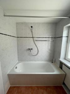 een badkamer met een wit bad en een douche bij Olympia Pension in Dachau