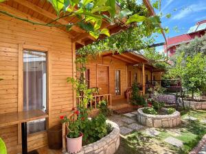 a house with a patio with plants in front of it at Cilek Butik Hotel in Cesme