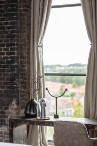 einen Tisch mit einer Uhr neben einem Fenster in der Unterkunft The Clock Tower in Weesp