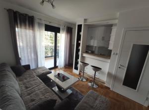 uma sala de estar com um sofá e uma mesa em Deluxe apartment Sunrise Trebinje em Trebinje