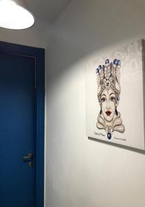 Un dipinto di una donna con una tiara su un muro di Appartamenti L'Approdo del Gabbiano a Lampedusa