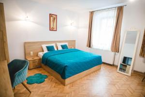 a bedroom with a bed and a chair and a window at Central House Morariu in Sibiu