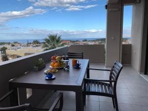 a table with fruit on a balcony with a view at Angela Apartments in Kato Daratso