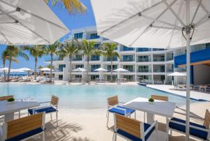 an image of the pool at the resort with tables and umbrellas at The Morgan Resort Spa & Village in Simpson Bay