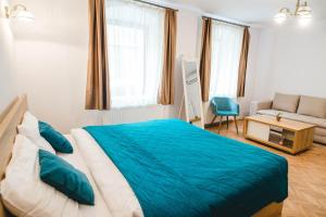 una camera da letto con un letto blu e un divano di Central House Morariu a Sibiu Altre 13 foto