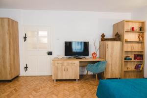 a room with a desk with a television and a door at Central House Morariu in Sibiu