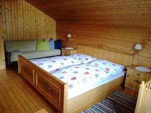 a bedroom with a bed in a wooden room at Stoffelehof in Großkirchheim