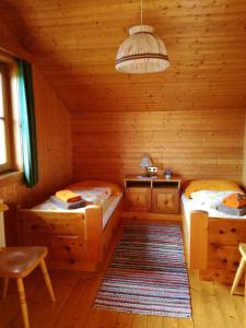 a room with two beds in a log cabin at Stoffelehof in Großkirchheim