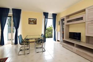 een eetkamer met een tafel en stoelen en een televisie bij CASA DEI LIMONI in Gardone Riviera