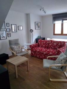 sala de estar con sofá rojo y sillas en Apartamento Sebreñu 2, en Ribadesella