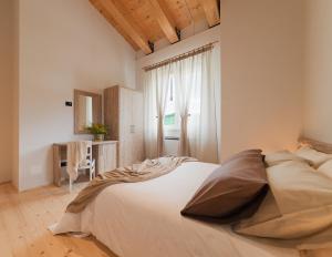 una camera da letto con un grande letto bianco e una finestra di Tenuta Grimaldi Wine Resort a Matelica